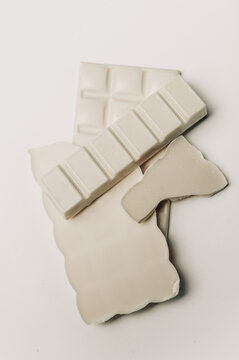 Broken white chocolate bar and pieces on white background