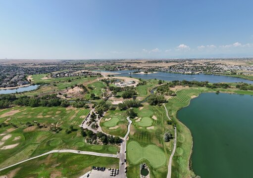 Aerial view of Pelican Lakes Point golf course featuring lush green fairways, winding paths, and expansive lakes in Windsor, Colorado, United States.