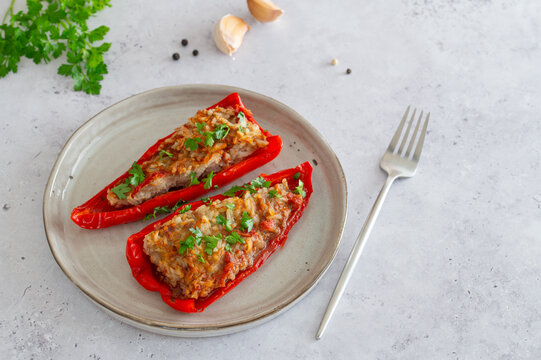 Stuffed sweet peppers on grey plate on stone