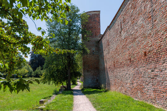 Medieval red brick city wall and defense watchtower with green pathway in Landsberg am Lech, Bavaria, Germany, historical tourism concept