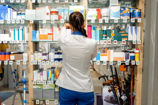 Pharmacist arrange healthcare product on pharmacy shelf