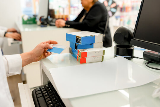 Pharmacist scan prescription medicine boxes at pharmacy counter