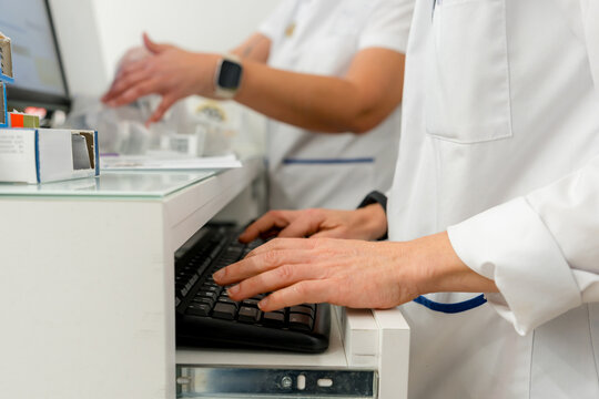 Pharmacist enter prescription data at pharmacy counter