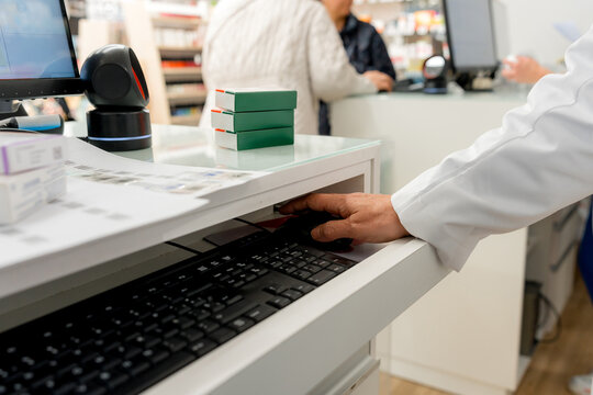 Pharmacist use computer at pharmacy counter for prescription service