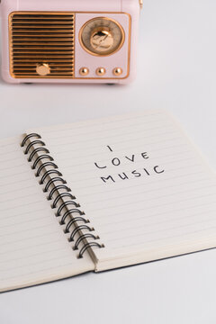 Spiral notebook with I love music text and pink vintage radio isolated on white