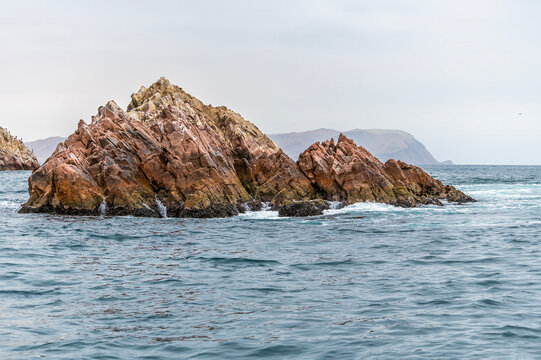 A view from a tourist boat towards a small islet in the Ballestas Islands, Paracas, Peru in the dry season