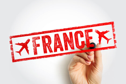FRANCE travel stamp text in rectangular frame, red ink style mark with airplane icons, hand holding marker, tourism concept showing country name as official arrival imprint