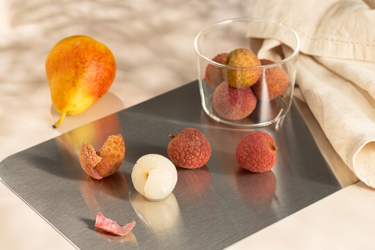 Lychee cocktail ingredients with pear and glass on tray