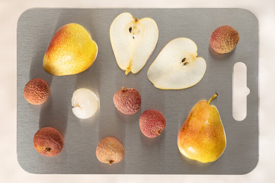 Lychee cocktail ingredients with fresh pear on cutting board