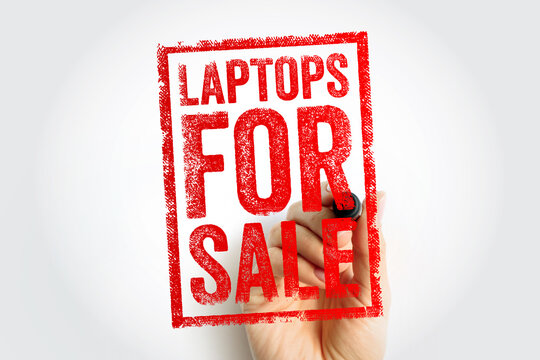 LAPTOPS FOR SALE text on a rubber stamp held by a person's hand. Perfect for advertising, retail deals, and computer hardware promotions.