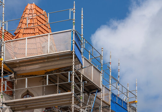 Renovation with scaffolding and tiled structure on historic building