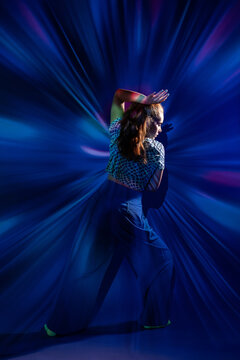 Young woman dance in colorful abstract light rays