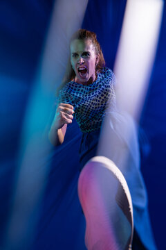 Young woman kick toward camera in neon nightclub