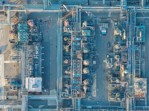 Aerial view of an industrial chemical plant featuring intricate networks of pipes, cooling towers, and storage tanks in Bantzenheim, Grand Est, France.
