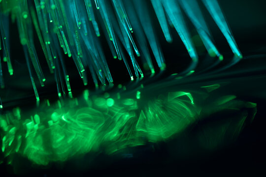 Glowing fiber optic strands on dark technology background