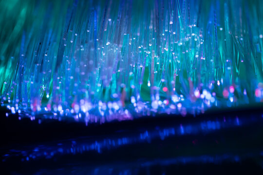 Fiber optic strands create glowing blue technology background
