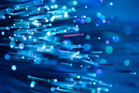 Fiber optic technology background with glowing blue light trails