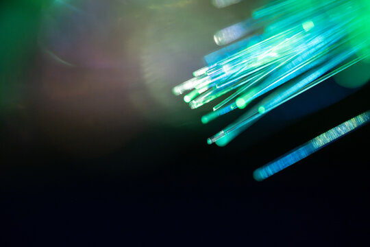 Fiber optic cable with glowing blue and green data light