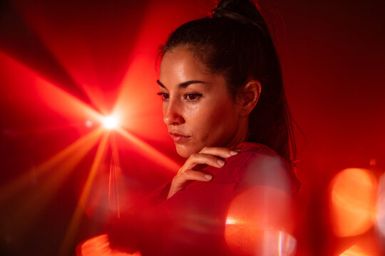 Latin woman dancer in red light with dramatic lens flare