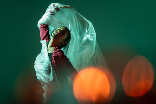 Latin woman dancer pose with translucent fabric and light
