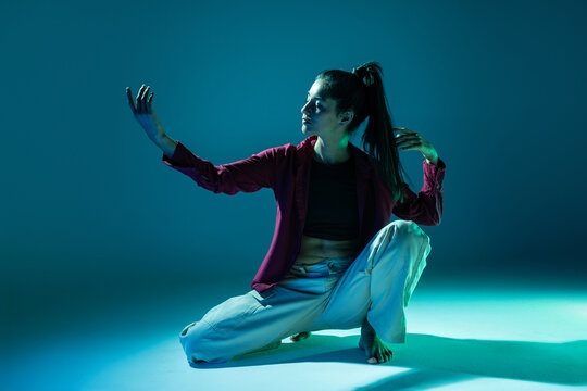 Latin woman dancer in dramatic blue  studio light