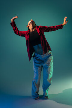Latin woman dancer pose with raised arms in studio