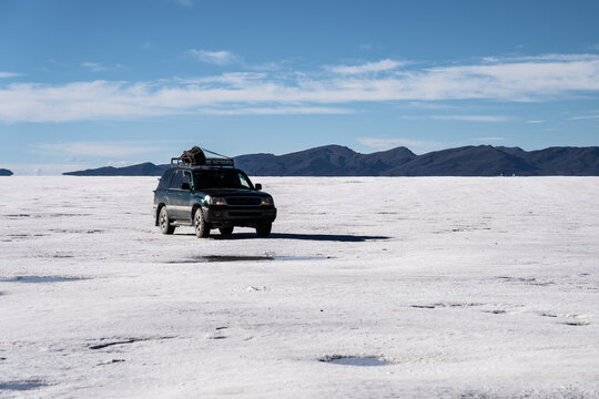Off-road vehicle crossing Salar de Uyuni salt flat