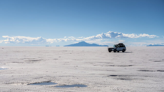 Off-road vehicle crossing Salar de Uyuni salt flat