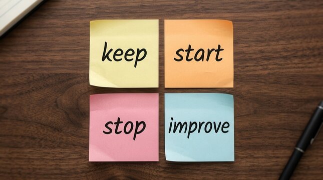 Keep start stop improve colorful sticky notes on a wooden desk for agile scrum teamwork development.