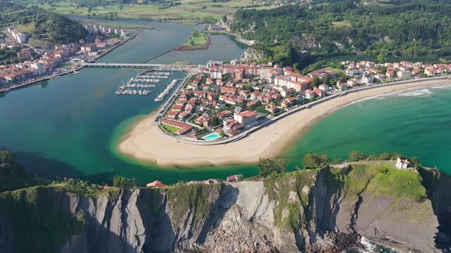 Aerial Panoramic View of Sunrise Over the Coastal Town of Ribadesella, Santa Marina Beach, Sella River Estuary, and Coastal Cliffs in Asturias, Northern Spain