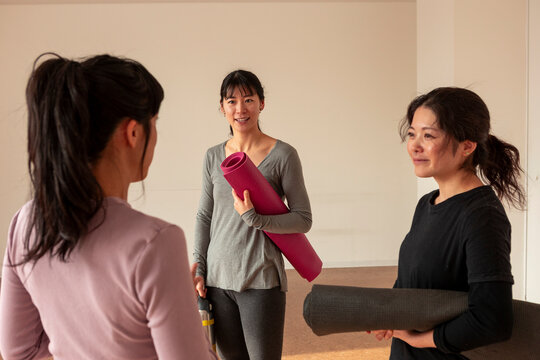 Japanese women gather for yoga class with exercise mats