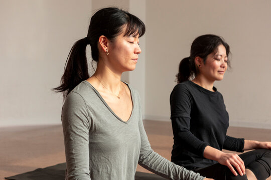 Japanese women meditate in a calm yoga class