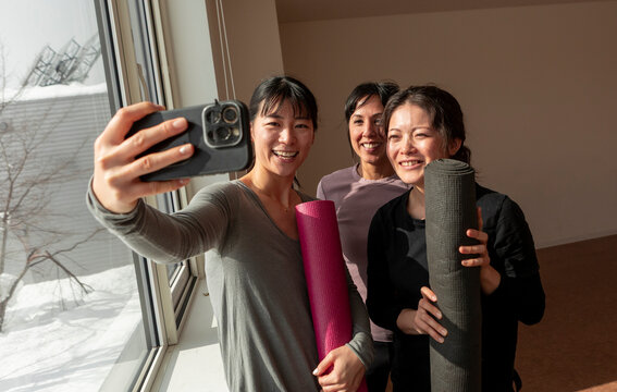 Japanese women take selfie with yoga mat after class
