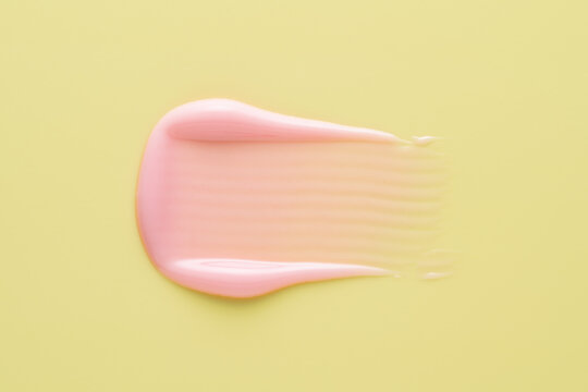 Pink lip gloss smear texture on yellow colorful background