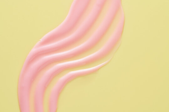 Pink lip gloss smear texture on yellow background