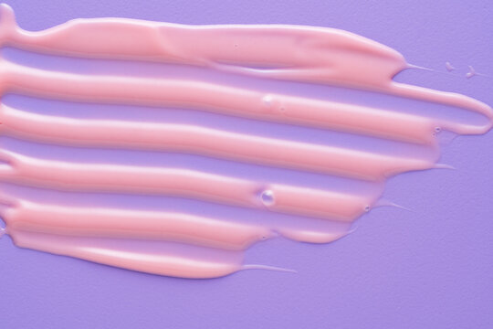Pink lip gloss smear on purple colorful background