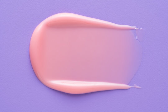 Pink lip gloss smear on purple textured background