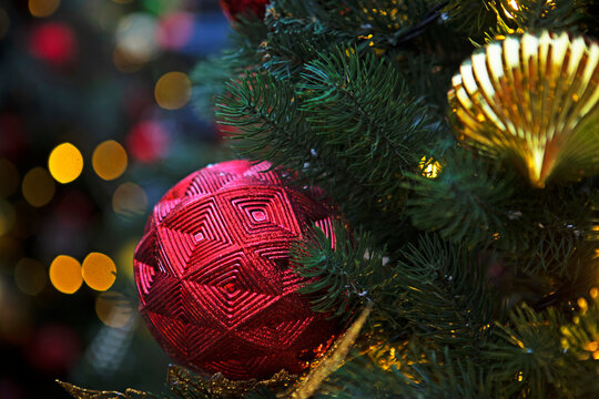 Red ball on a Christmas tree. New Year or Christmas. Christmas card background. New Year's bokeh in the background. Advertising background