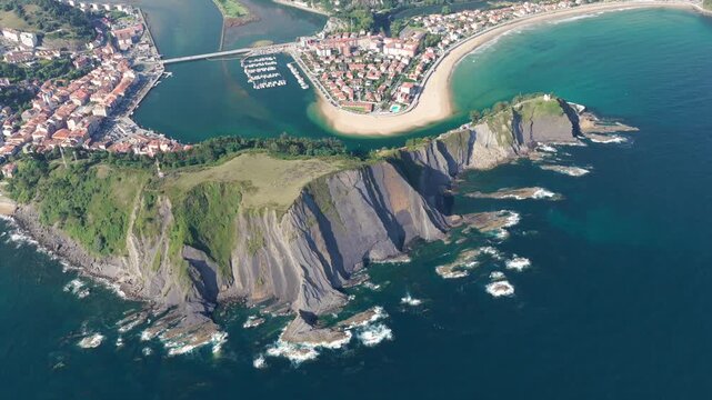 Aerial Panoramic View of Sunrise Over the Coastal Town of Ribadesella, Santa Marina Beach, Sella River Estuary, and Coastal Cliffs in Asturias, Northern Spain