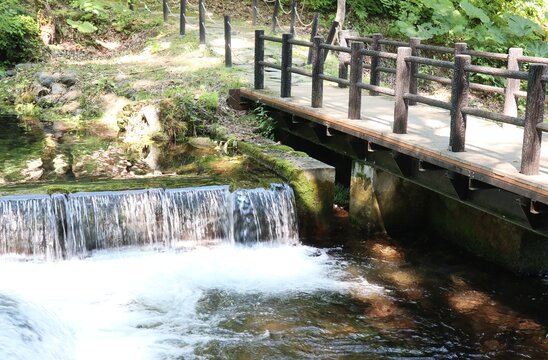 勢いよく水が流れ落ちる清流と橋の風景