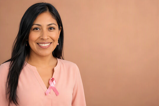 Smiling Latin Indigenous Woman with Pink Breast Cancer Awareness Ribbon on Blouse, Ethnic Diversity Empowerment Hope and Women Health Portrait with Copy Space on Clean Beige Background