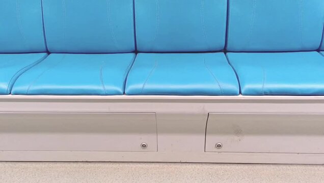 Empty blue passenger seats inside modern public transit train interior