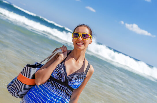 A smiling young woman on a sunny day at the seashore.