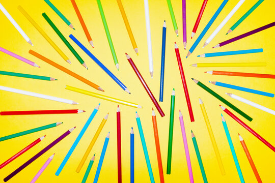 Color pencil arrangement on yellow background for drawing art
