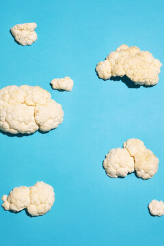 Cauliflower florets arranged like clouds on blue background