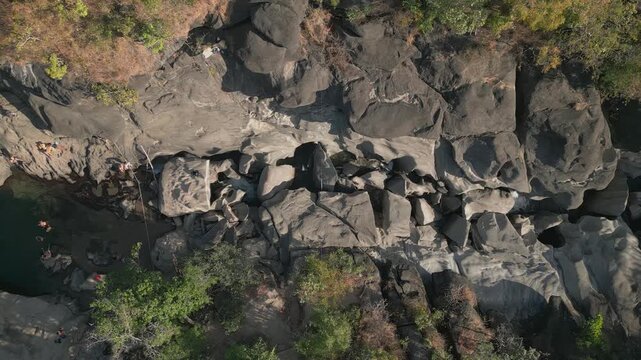 Sculpted quartzite bedrock along the Sao Miguel River at Vale da Lua, Chapada dos Veadeiros National Park, Alto Paraiso de Goias, Goias, Brazil, top down drone slide.