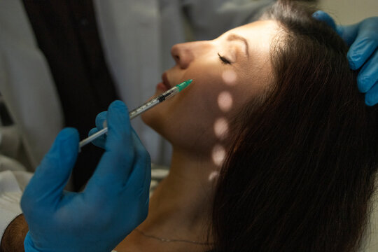 Doctor administers facial injection at beauty clinic
