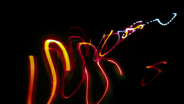 Abstract long exposure light painting photography featuring vertical looping red and orange neon streaks ending in a dotted cyan trail against a pitch-black background