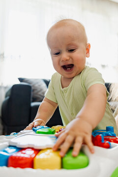 Happy baby playing with colorful educational toy