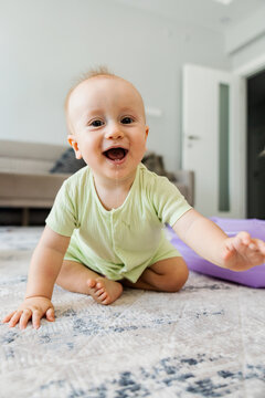Smiling baby crawl on carpet at home